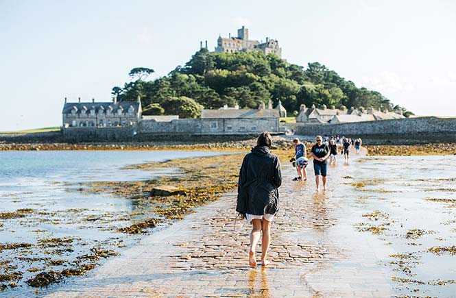 People walking along the stone causeway to St Michael's Mount in Cornwall