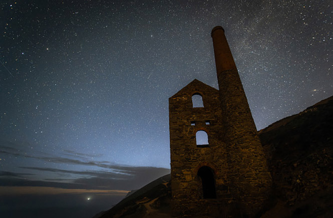 The engine house at Wheal Coates at night with a starry sky above