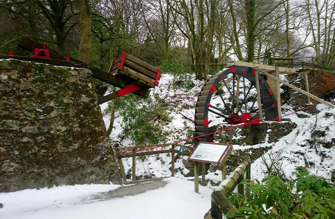 A waterwheel at Wheal Martyn covered in snow