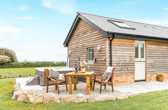 A barn with hot tub, surrounded by fields