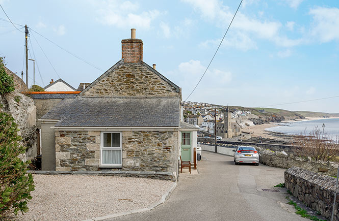 A granite cottage at the top of a hill with views across the sea and coastline