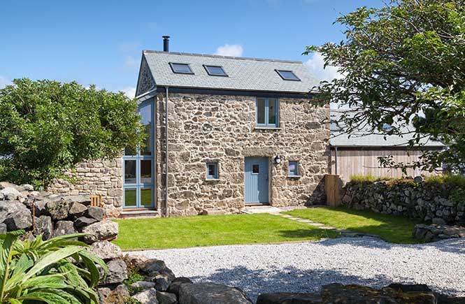 A granite barn with blue doors and windows