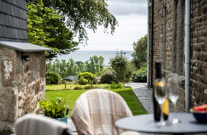 An outdoor table and chairs looks out to sea views.