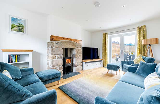 A large lounge features plush teal sofas and a granite fireplace