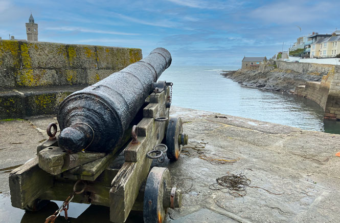 A canon is positioned at the harbour's edge
