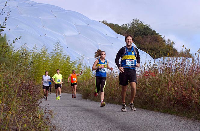 People running the Eden Marathon with the Eden Project biomes in the background