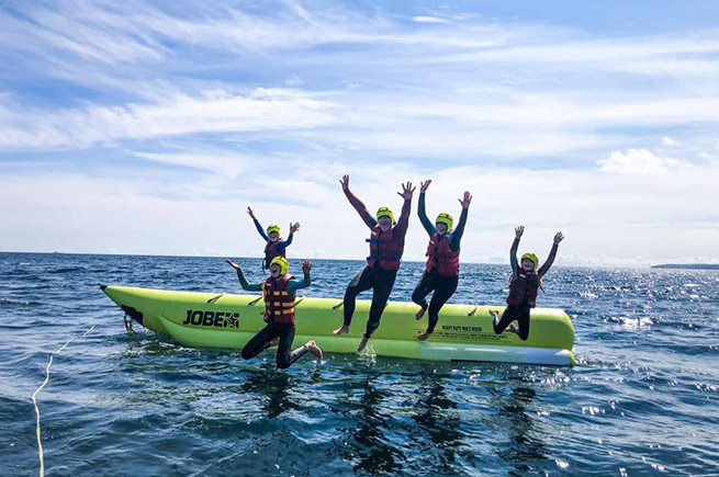 People having fun jumping off a banana boat with Cornwall Waverunner Safaris