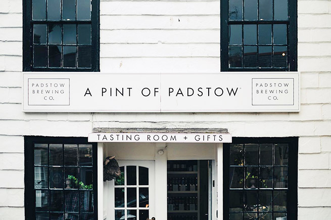 The white, wood-clad front of Padstow Brewing Company tasting room and gift shop in Padstow