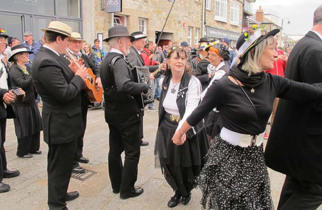 People dancing around in traditional Cornish dress for May Day in St Ives