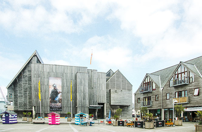 The wooden exterior of the National Maritime Museum Cornwall with the harbour in the background