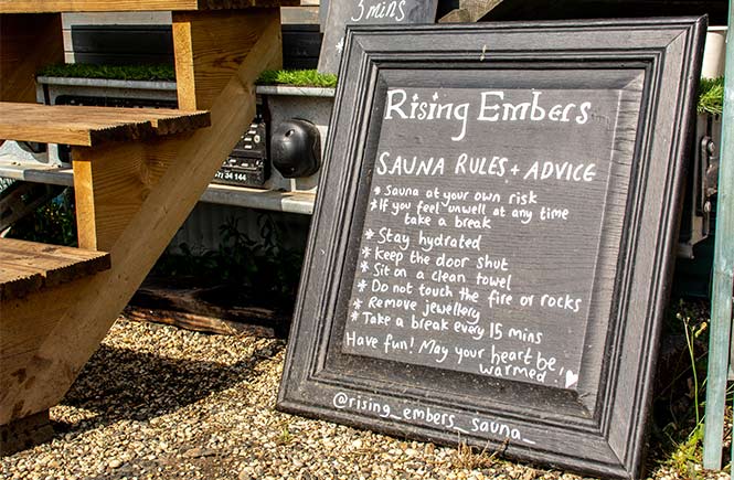 A wooden sign listing advice for sauna use at Rising Embers in Cornwall