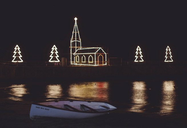 Christmas lights in the shape of a church and stars along the harbour wall in St Ives