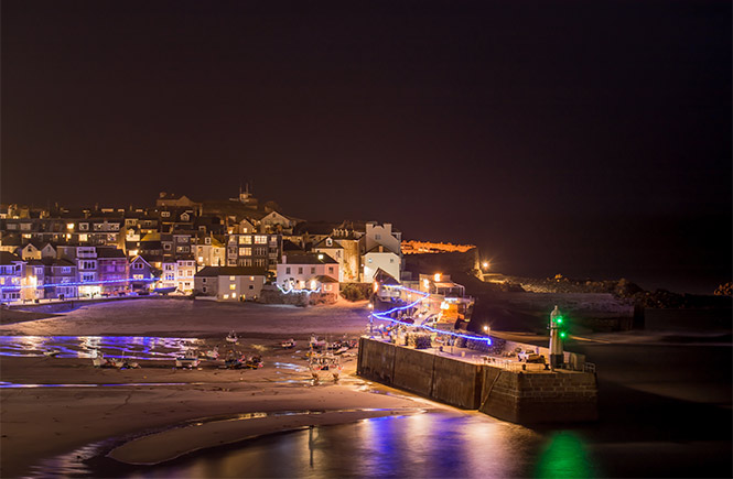 St Ives harbour lit up by Christmas lights at night